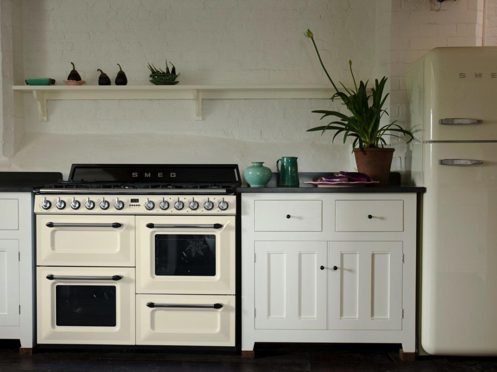 Smeg fornuis en retro koelkast in crème tussen witte landelijke keukenkasten