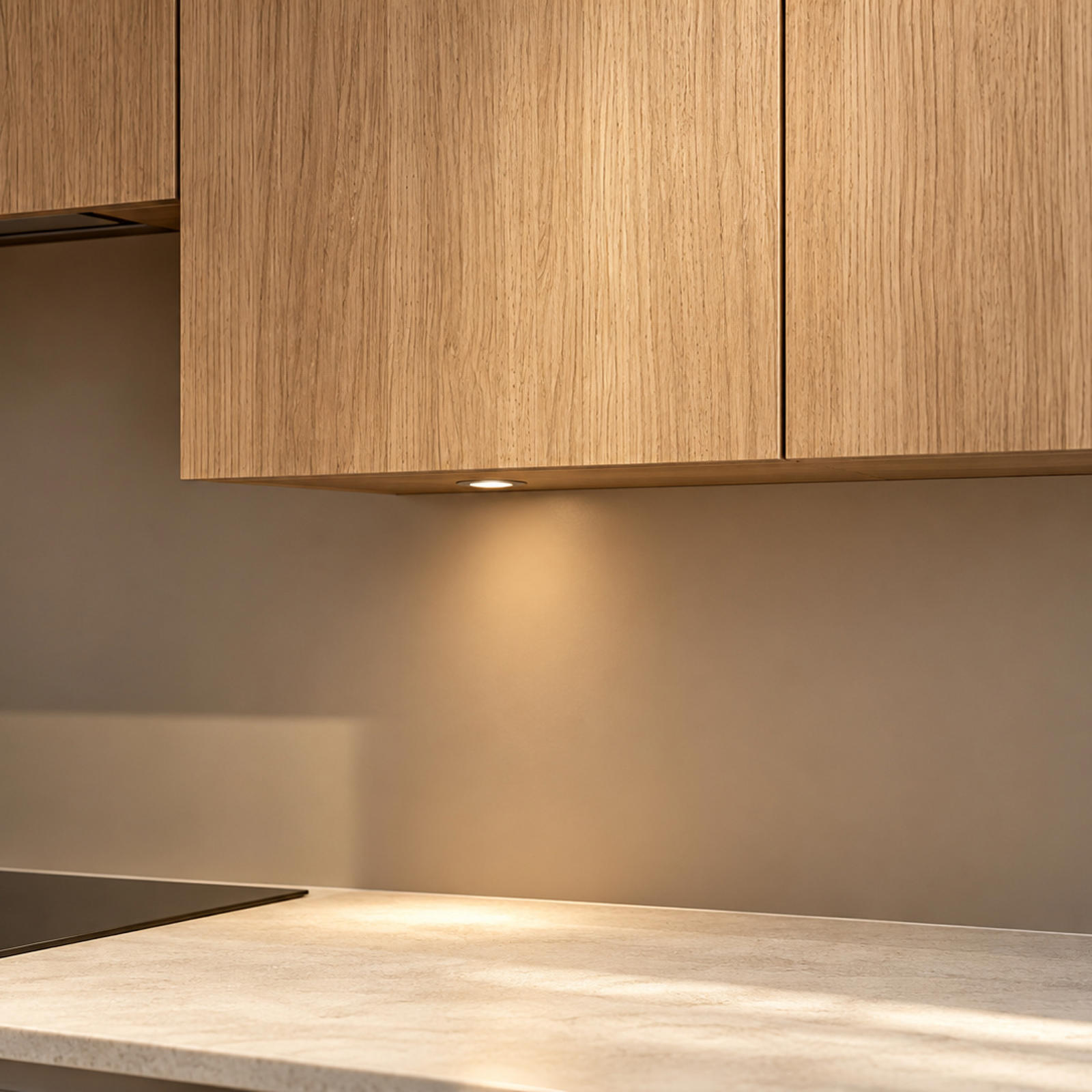 Eiken bovenkasten met onderbouwverlichting boven het werkblad en de inductiekookplaat