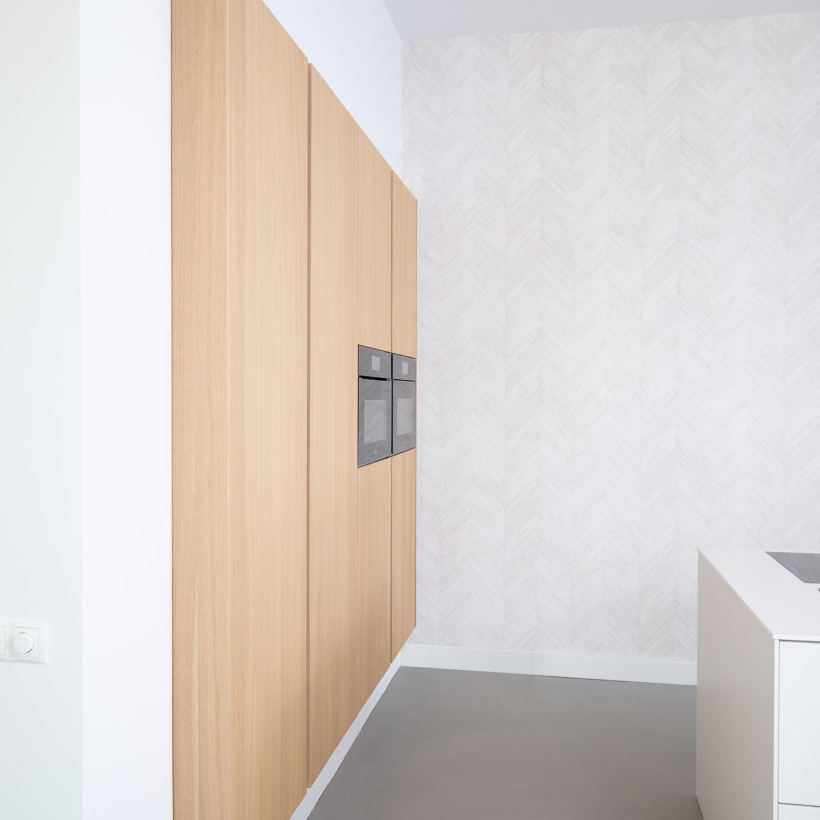 Zwevende hoge kasten in lichte houtlook met twee inbouwovens
